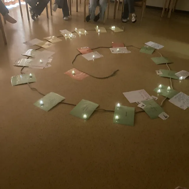 Jugendliche im Konficamp haben Gedanken auf Zettel geschrieben und spiralförmig ausgelegt