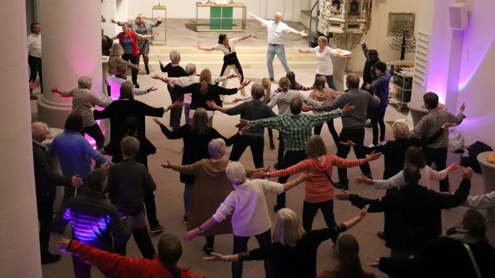 Menschen tanzen in der Kirche und breiten die Arme aus